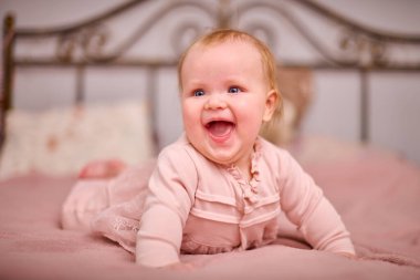 Açık renk saçlı, beyaz ırktan, pembe elbiseli, neşeli genç bir kadın. Ilık aydınlatma neşeli ifadeyi artırır. Yumuşak dekor samimi dokunuş ekler