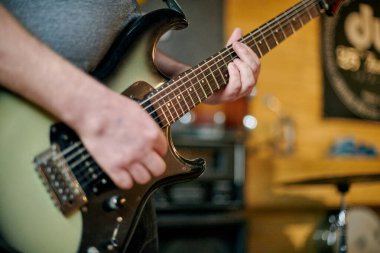 Elektronik bas gitar çalan müzisyenlerin ellerini kapatın, pratik performansı sırasında parmak yerleştirme ve frets üzerinde yoğunlaşın