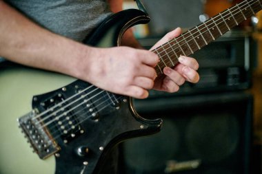 Elektronik bas gitar çalan müzisyenlerin ellerini kapatın, pratik performansı sırasında parmak yerleştirme ve frets üzerinde yoğunlaşın
