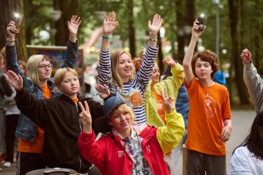 Kaliningrad, Rusya - 11.08.2024 - çeşitli gençler ve yetişkinler park festivali, canlı kıyafetler, sıcak öğleden sonra, ağaçlar, mutluluk