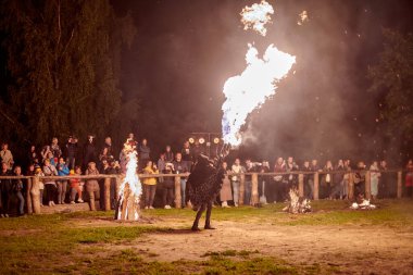 Kaliningrad, Rusya - 10.09.2022 - Çift alev fırlatıcı sanatçılar gece gökyüzüne muazzam alev akıntıları salıyor, ateş ustalığını ve ateş performansını temsil ediyor