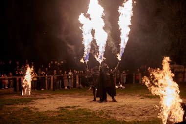 Kaliningrad, Rusya - 10.09.2022 - Çift alev fırlatıcı sanatçılar gece gökyüzüne muazzam alev akıntıları salıyor, ateş ustalığını ve ateş performansını temsil ediyor