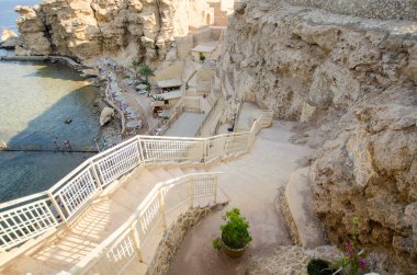 Cliffside Resort 'ta el değmemiş plaja çıkan merdivenler var. Engebeli kayalar, dingin su, güneşli atmosfer sakin bir açık hava kaçışı yaratır. Doğal ortamdaki sahil zarafeti