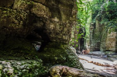 Güneş ışığı kanyonu yüksek taş duvarlarla çevrili kayalık bir yol içerir. Yukarıdan yemyeşil çağlayanlar huzurlu doğal atmosfer yaratıyor. Gölgeler ve ışık manzaraya derinlik ekler