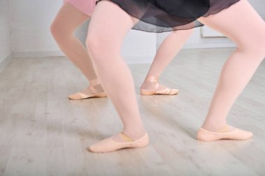 Parlak stüdyodaki bale barında prova yapan genç balerinler. Soluk ahşap döşeme kontrast pembe giysi ile, zarafet yakalamak ve onların dans pratik hassasiyeti