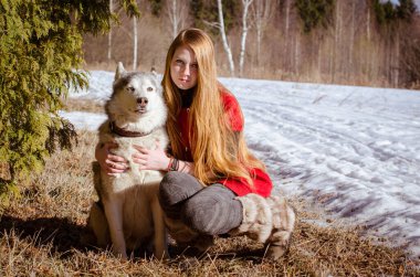 Uzun kızıl saçlı, iri yapılı, karlı ormanda yaşayan genç bir kadın. İkisi de ağaç zeminli kahverengi çimlerin üzerinde oturuyordu. Güneş ılık bir ışık saçar, dinginlik katar.