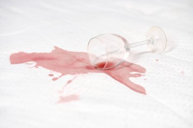 Kırık kadehler beyaz tekstil üzerinde, kırmızı lekeye neden olur. Yüksek anahtarlı ışıklandırma kontrastı arttırır. Olay yeri kazara döküldüğünü ve potansiyel temizlik sorunu olduğunu gösteriyor.