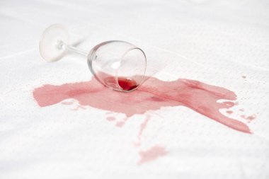 Beyaz kumaş üzerine düşen cam zengin kırmızı bir leke yaratır. Derin sızıntı ve parlak arka plan arasındaki zıtlık. Sahne kazara ama dinamik bir aksilik taşıyor