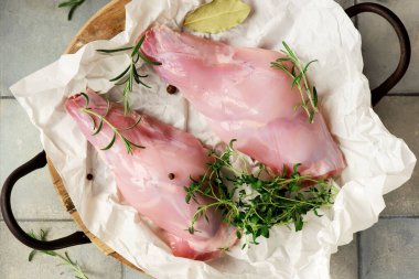 Taze bitkilerle çiğ tavşan bacağı. Stil sarılma. Seçici odaklanma.