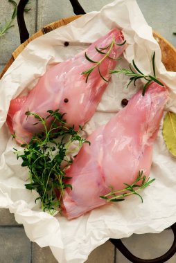 Taze bitkilerle çiğ tavşan bacağı. Stil sarılma. Seçici odaklanma.