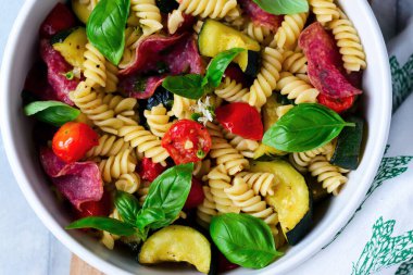 Kabaklı makarna, domates, salam ve Basil. Üst düzey. Seçici odaklanma