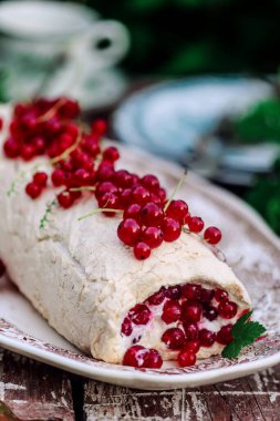 Bahçede kırmızı üzümlü Pavlova sarması. Klasik tarz. Seçici odak noktası.