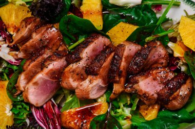 Fried duck breast in honey soy glaze with mixed salad and oranges.top veiw .style rustic.selective focus clipart