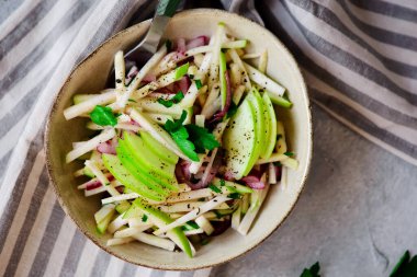 Elmalı kereviz kökü lahana salatası ve seramik kase. Tarz rustik.Seçici odak