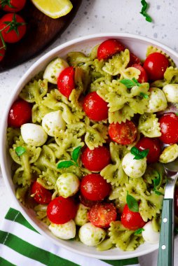 Pesto soslu makarna, vişneli domates ve mozzarella... tarz sarılma. Seçici odaklanma. Üst veiw 