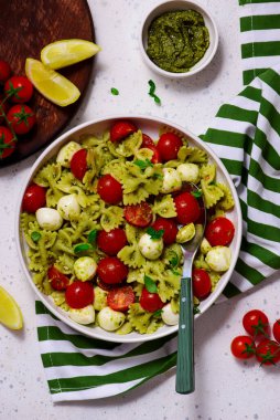 Pesto soslu makarna, vişneli domates ve mozzarella... tarz sarılma. Seçici odaklanma. Üst veiw 