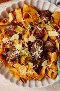 Seramik kasede parmesanlı tavuk ciğeri makarna. Üst seçici odak noktası