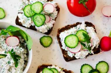 Süzme peynirli, otlu ve turplu kanepeler. Üst görünüm. Seçici odak