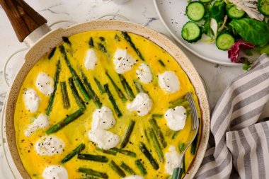 Kuşkonmaz ve tavada keçi peynirli omlet, avokado ve yeşil salata. Üst düzey seçici odak