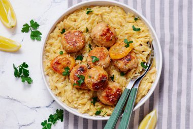 Fırında limonlu tavuk köftesi ve kremalı orzo. Üst seçici odak noktası
