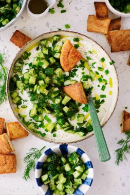 Salatalık, dereotu ve yeşil soğan salatasıyla çırpılmış feta ve kızarmış pide parçaları. Seçici odaklanma. Üst veiw