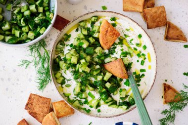 Salatalık, dereotu ve yeşil soğan salatasıyla çırpılmış feta ve kızarmış pide parçaları. Seçici odaklanma. Üst veiw