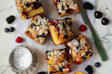 İsveç böğürtlenli turta, dilimlenmiş ve üzerine pudra şekeri serpiştirilmiş.