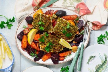 Ekmek kırıntısı kabuklu morina filetosu ve fırında sebze kökü.