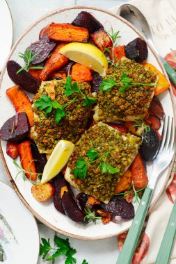 Ekmek kırıntısı kabuklu morina filetosu ve fırında sebze kökü.