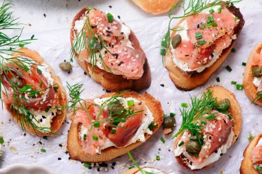 Baguette Crostini with Cream Cheese and Pink Pacific Salmon..style hugge. top veiw.selective focus clipart