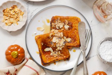 Akçaağaç şurubu, badem ve pudra şekerli balkabaklı Fransız tostu.