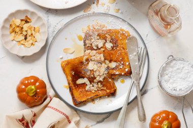 Akçaağaç şurubu, badem ve pudra şekerli balkabaklı Fransız tostu.