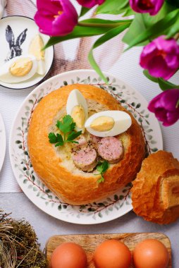 Geleneksel Polonya Paskalya Çorbası Zurek bir somun ekmek, tütsülenmiş et ve yumurta ile servis edilir.