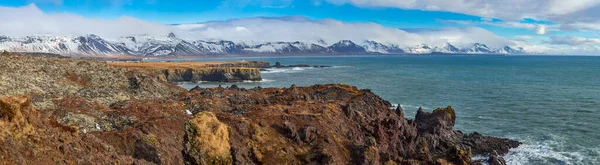 冰岛海岸上的村庄 背景中俯瞰汹涌的大海和风景如画的云彩 — 图库照片