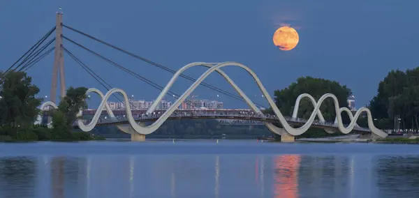 Yeni dalga köprüsündeki insanlar dolunaya hayran, Kyiv, Ukrayna.