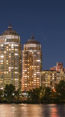 Kyiv şehrinde gece görüş alanı Dinyeper nehri önplanda ve aydınlatılmış evler ve güzel gece gökyüzü yıldızları ve görünen kuyruklu yıldız Tsuchinshan-ATLAS ile 17 Ekim 2024.