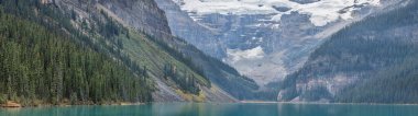 Kanada Banff Ulusal Parkı 'ndaki Louise Gölü' nün nefes kesici manzarası. Turkuaz sular, yüksek dağları, gür çam ormanlarını ve görkemli buzulları yansıtır. Resmedilmeye değer bir manzara yaratır..