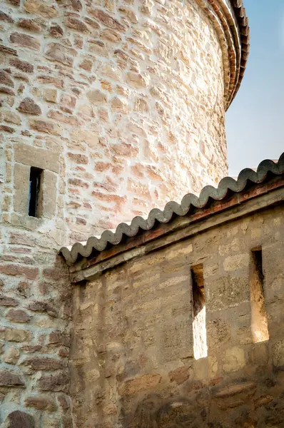 小さな窓のある古い石造りのタワーのクローズアップは テクスチャの表面と伝統的な建築デザインを示しています 自然光によって照らされる — ストック写真