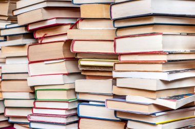 Yığınla yıpranmış dikenli renkli ciltli kitap. Renklerin çeşitliliği ve yaşlılık görünüşü farklı konuları okuma ve keşfetme sevgisi olduğunu gösteriyor..