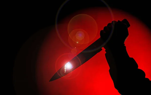 赤いスポットライトでナイフで怖い手のシルエット — ストック写真