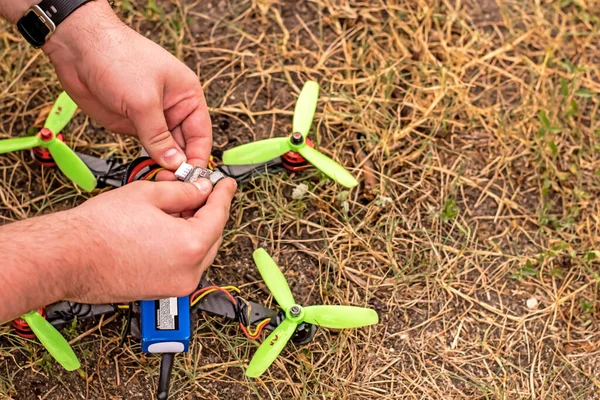 Erkek eller yerdeki DIY İHA üzerinde çalışıyor.