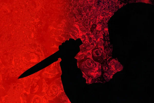 暗赤色の環境でナイフを持った男のシルエットイラスト — ストック写真