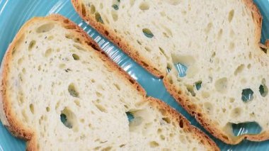 Lazio bölgesinden bir dilim İtalyan sade buğday ekmeği. Yakın çekim, dönüşümlü video..