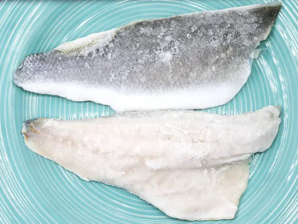 Mavi tabakta donmuş balık deniz levreği filetosu..