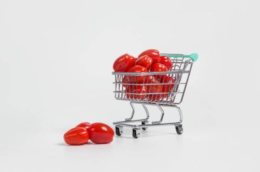 Alış veriş arabasındaki domatesler hafif arka planda
