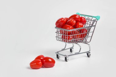 Alış veriş arabasındaki domatesler hafif arka planda