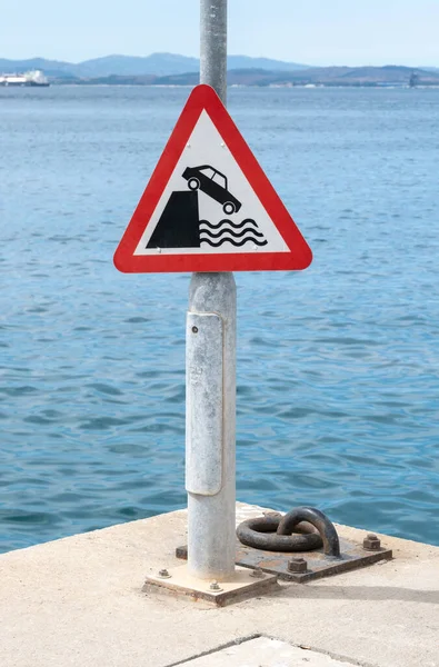 Red triangle warning sign making drivers aware that vehicle could fall into deep water.