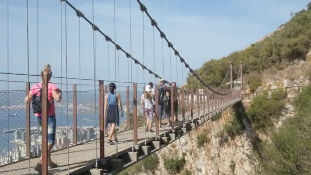 アッパー ロック ジブラルタル 2022年10月24日 ジブラルタルのアッパーロック自然保護区の50メートルの峡谷の上に位置するウィンザー吊り橋を歩いている観光客の家族グループ — ストック動画