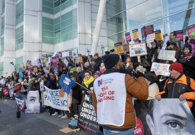 London, UK. 18th January 2023. Striking nurses with placards and banners, demonstrating outside the main entrance of University College Hospital, London, in protest to government cuts and unfair pay.