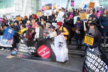 London, UK. 18th January 2023. Striking nurses with placards and banners, demonstrating outside the main entrance of University College Hospital, London, in protest to government cuts and unfair pay.